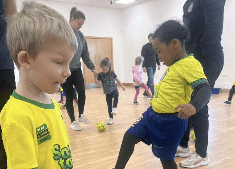 Toddler football club in Bedford. Image shows toddlers taking part in a Socatots class with their parents.