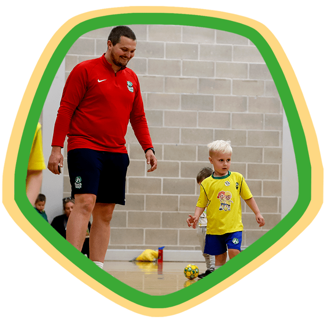 SOCATOTS boy standing next to a SOCATOTS football coach