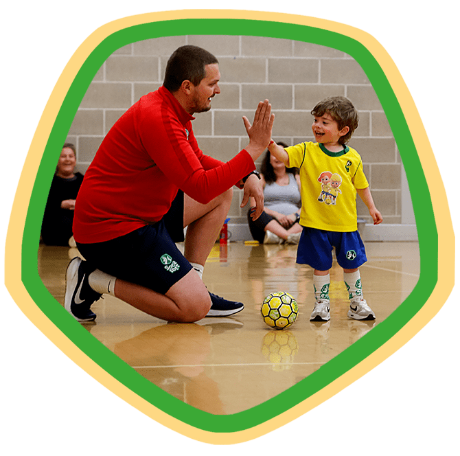 Toddler giving a SOCATOTS coach a high five