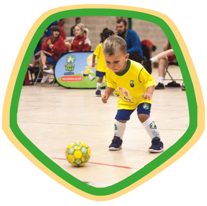 Toddler staring at a football ready to play