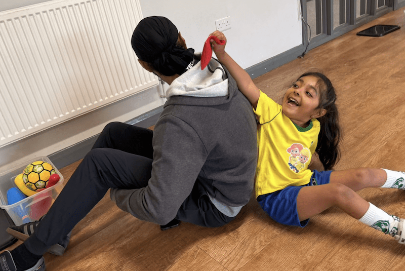 Playtime activities for toddlers. Image shows a girl and her dad at a socatots class.