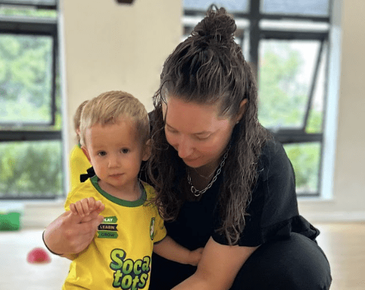 Activities for baby and toddler. Image shows a toddler with their mum in Socatots kit at a Socatots class.