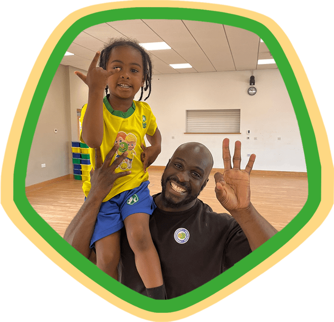 Image shows a son on his fathers shoulders having fun during a Socatots class