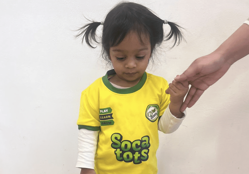 Toddler football club in Staffordshire. Image shows toddler in Socatots uniform holding her parent's hand during a Socatots class.